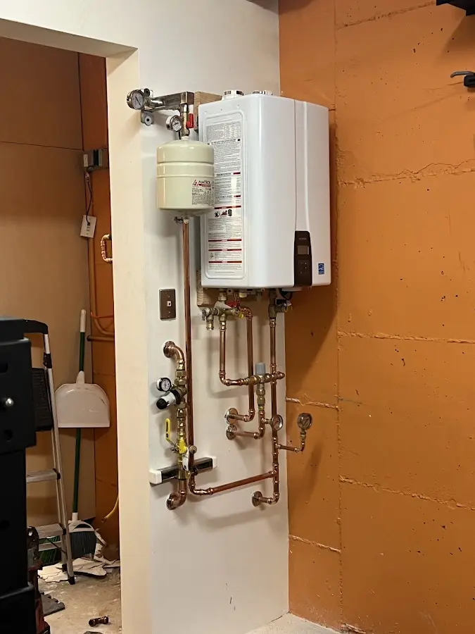 Plumbing technician inspecting water heater connections in Rockfish